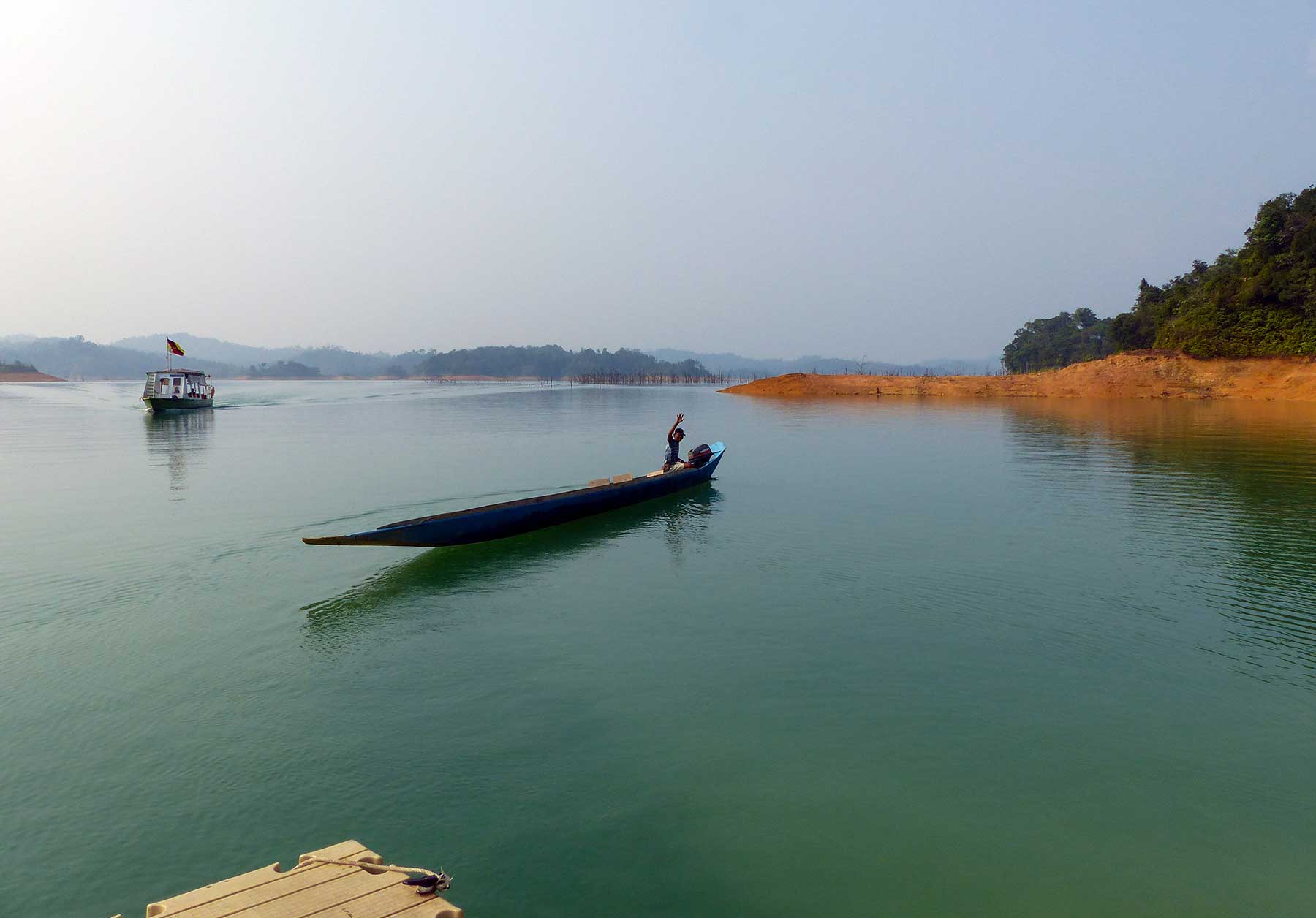 Man zwaait in een boot op het water in het Batang Ai Nationaal Park, Maleisisch Borneo