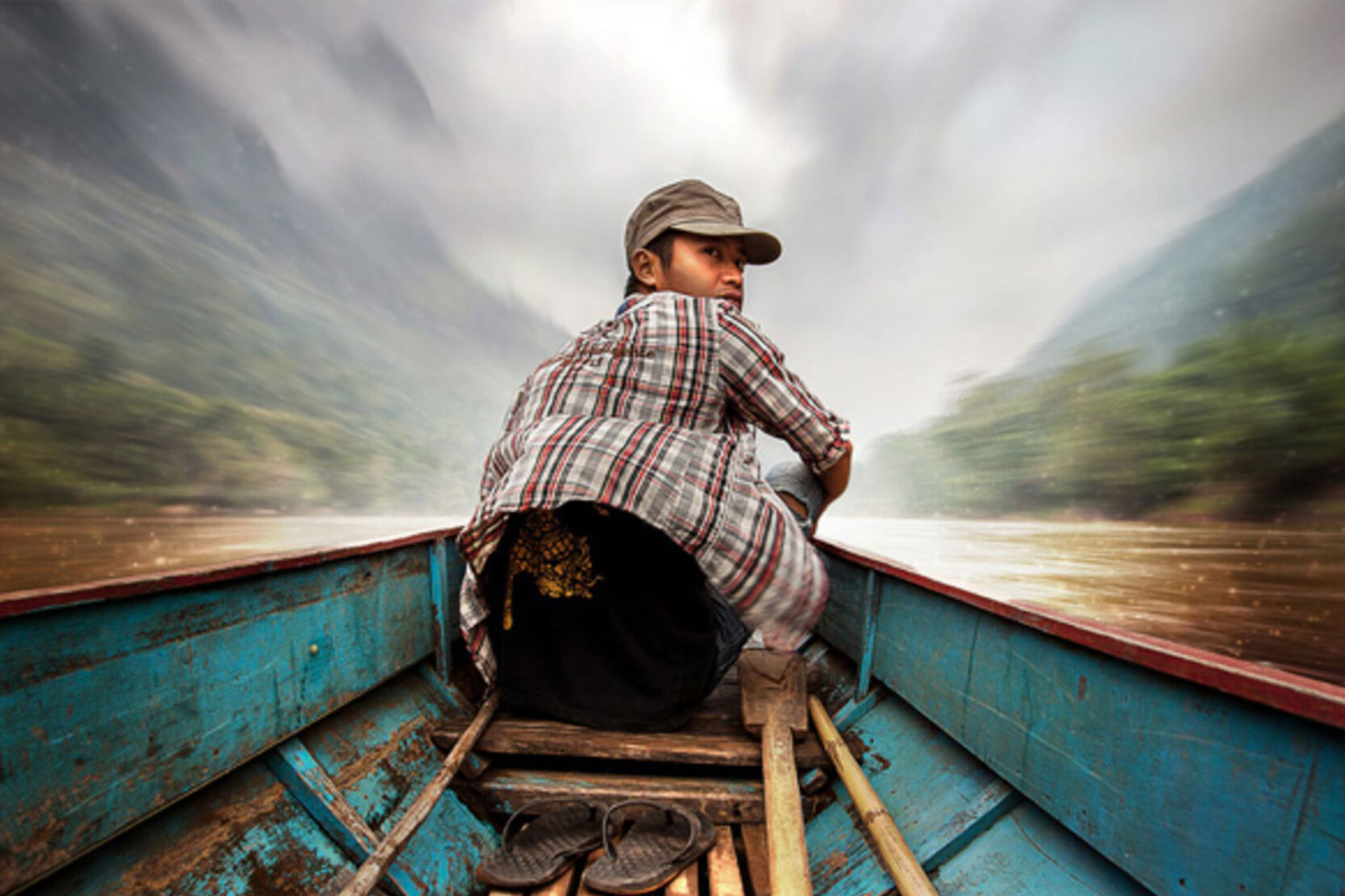 Jongen in een boot. Beeld uit de documentaire Banana pancakes and the children of sticky rice
